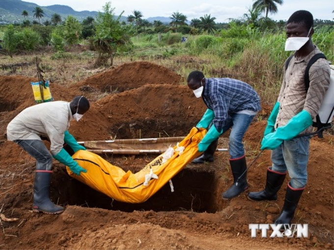 Nhân viên tình nguyện trong trang phục bảo hộ chôn xác nạn nhân Ebola tại Waterloo, cách thủ đô Freetown, Sierra Leone khoảng 30km ngày 7/10. (Nguồn: AFP/TTXVN)